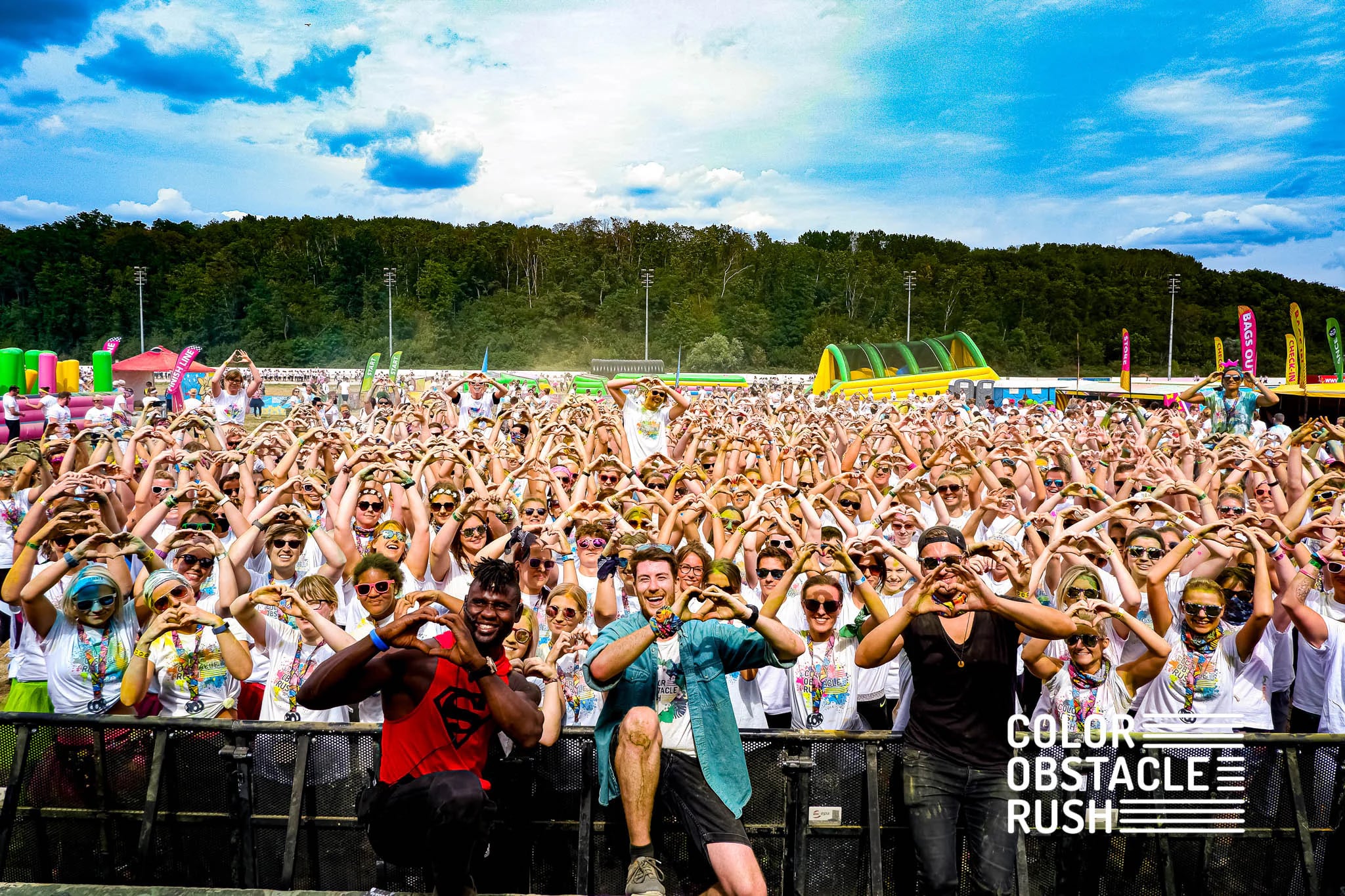 Festival-Publikum formt Herzen mit den Händen beim Color Obstacle Rush